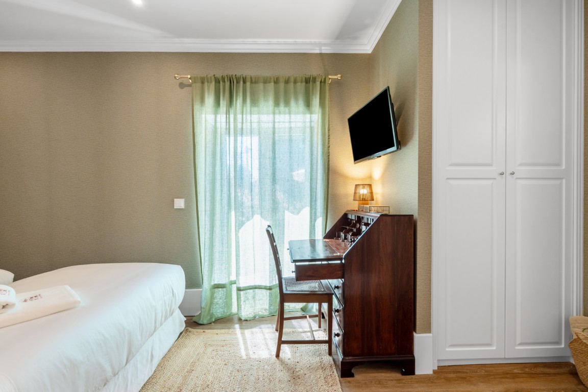 Quarto clássico com nicho de livros e televisão